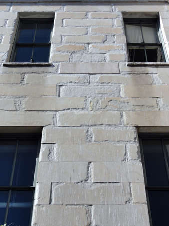 Close-up of side of San Francisco Mint Building with granite wall and windows with bird in window edge. the Old United States Mint, also known affectionately as The Granite Lady, is one of the few that survived the great 1906 San Francisco earthquake.の写真素材