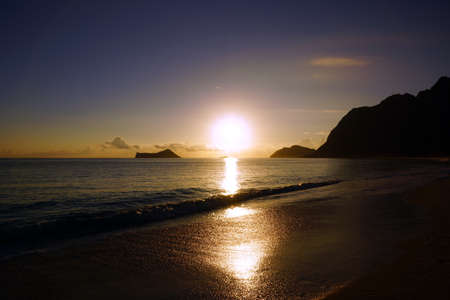 Early Morning Sunrise on Waimanalo Beach on Oahu, Hawaii over Rock Island bursting through the clouds. 2013.の写真素材
