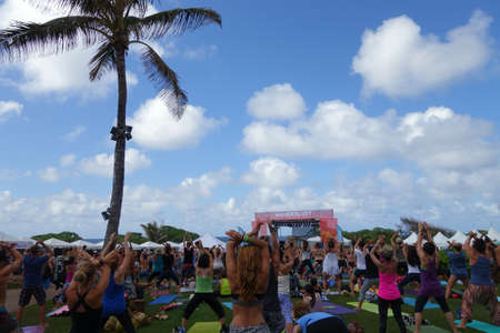 NORTH SHORE, HAWAII - MARCH 1:  People raise arms over head during outdoor yoga class along the ocean at Wanderlust yoga event on the North Shore, Hawaii on March 1, 2015.のeditorial素材