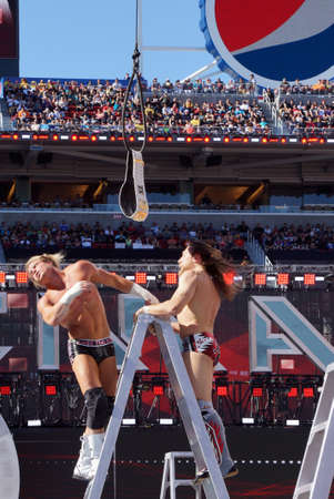 SANTA CLARA - MARCH 29: Dolph Ziggler falls off ladder after a headbutt with Daniel Bryan with hair flying on top ladder for the Intercontinental championship belt as it hangs in the air with  during ladder match at Wrestlemania 31 with crowd in the distaのeditorial素材