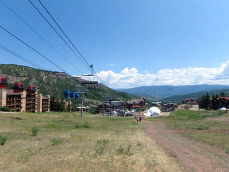 SNOWMASS, CO - JULY 4:  People walk along path during Wanderlust festival at Snowmass Village area mountains, with ski lifts, condos, road, and trees in Colorado on July 4, 2015.のeditorial素材