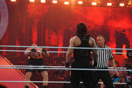 SANTA CLARA - MARCH 29: WWE Champion Brock Lesner leans back as he holds rope as he enters ring with Roman Reigns standing in ring at, showcase of the immortals, Wrestlemania 31,with fans cheering and taking photo at the Levi's Stadium in Santa Clara, Calのeditorial素材