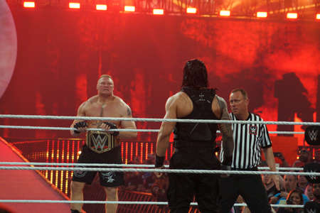 SANTA CLARA - MARCH 29: WWE Champion Brock Lesner stares across ring at Roman Reigns as he holds rope as he enters ring standing in ring sit at, showcase of the immortals, Wrestlemania 31, with fans cheering and taking photo at the Levi's Stadium in Santaのeditorial素材