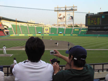 SEOUL, SOUTH KOREA - MAY 31: Fan photographs baseball game with digital camera in Seoul, South Korea May 31, 2005.のeditorial素材