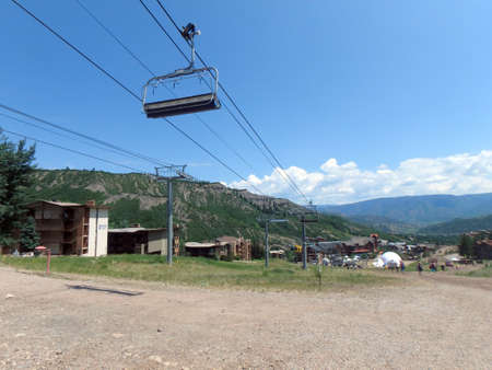 SNOWMASS, CO - JULY 4:  People walk along path during Wanderlust festival at Snowmass Village area mountains, with condos, road, and trees in Colorado on July 4, 2015.のeditorial素材