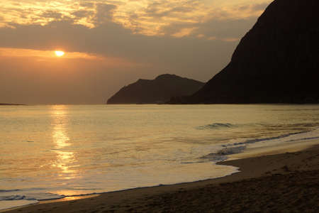 Early Morning Sunrise on Waimanalo bay going into the clouds and beach Oahu, Hawaii.の写真素材