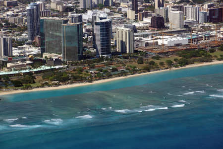 Aerial of Ala Moana Beach Park, mall, condos, and Cityscape of Honolulu on Oahu, Hawaii with waves lapping in from the ocean.の写真素材