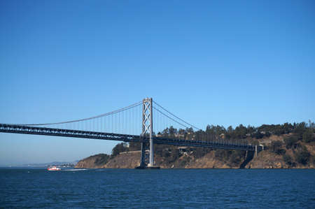 Bay Bridge, yerba buena island and boat sailing under on a nice day in California.の写真素材