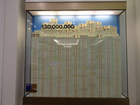 DENVER, COLORADO - JULY 7: Stack of Hundred dollar bills in glass display case equally 30 million dollars inside United States Mint in Denver, Colorado.  July 7, 2015.のeditorial素材