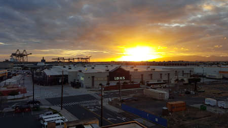 HONOLULU - APRIL 10: Sunset over Lowe's and Shipping Cranes with Matson Shipping containers around building on Oahu, Hawaii April 10, 2016.  Lowe's Companies, Inc. is an American company that operates a chain of retail home improvement and appliance storeのeditorial素材