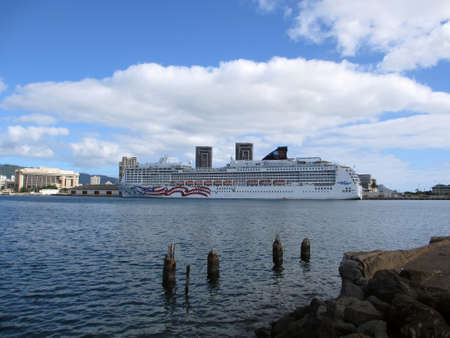 HONOLULU, HI - JANUARY 7: NCL Cruiseship, Pride of America,  docked in Honolulu Harbor with city and mountains in the distance.  taken January 7, 2012 Honolulu, Hawaii.のeditorial素材