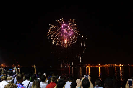 HONOLULU - JANUARY 1: New Years Fireworks burst in the air as people watch and record display smartphones at Outdoor New Years Party along the water on January 1, 2016 in Honolulu, Hawaii.のeditorial素材