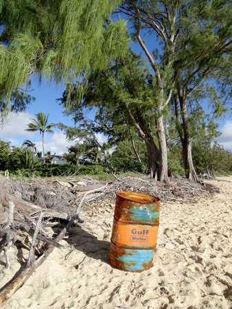 Waimanalo - July 11, 2016: Wash-up Gulf Marine Oil Barrel sits on Waimanalo Beach on Oahu, Hawaii with ironwood trees in the brackground.のeditorial素材