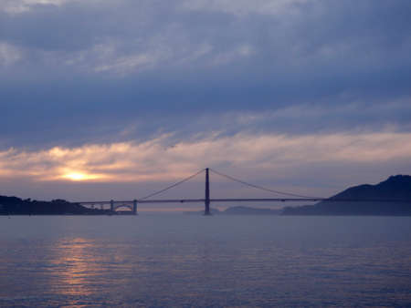Sunset over San Francisco Bay and the Golden Gate Bridge with birds in the air and awesome clouds in the sky in California.  March 16, 2010.のeditorial素材