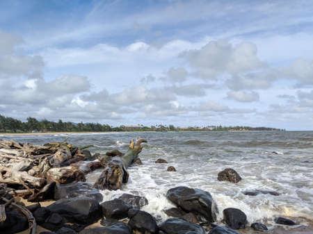 Waves along rocky shore with drift wood at Lydgate park on Kauai.の写真素材