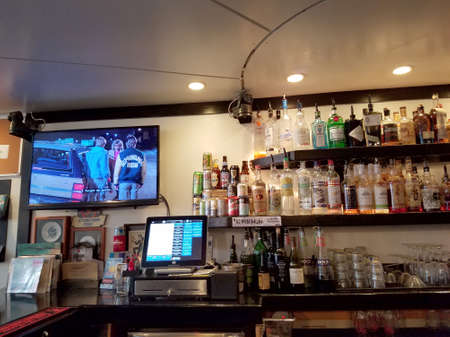 Honolulu - August 6, 2017: Movie plays on TV inside Local Downbeat Diner Bar with liquor on display...