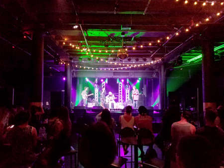 Honolulu - May 2, 2017: Musicians Tavana, Tommy Osuna, and Zach Gray play guitar and sing on stage at Crossroads in Hawaiian Brian's with cool lighting on May 3, 2017, Honolulu, Hawaii.のeditorial素材