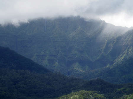 Waterfall bejeweled Namolokama mountain in the Hanalei Valley on Kauai with clouds covering mountain top.の写真素材