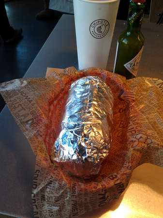 San Francisco - November 12, 2011: Wrapped Burrito with drink and green tabasco at Chipotle. With more than 1600 locations, Chipotle had a net income in 2013 of US$327.4 million and a staff of more than 45,000 employees.のeditorial素材