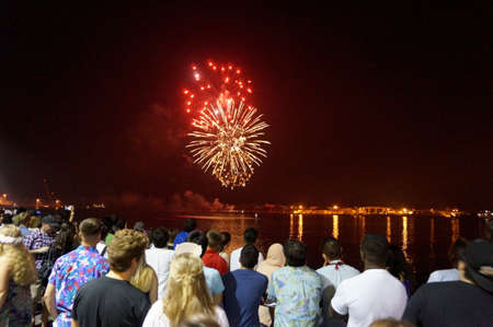 Honolulu - January 1, 2016: New Years Fireworks burst in the air as people watch and record display smartphones at Outdoors New Years Party along the water on January 1, 2016 in Honolulu, Hawaii.のeditorial素材