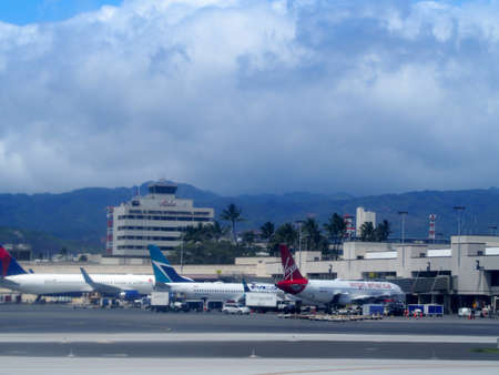 Honolulu - April 11, 2018: Delta, Virgin America, and other Airlines planes sit at terminal as they awaiting next fight at Honolulu International Airport, Honolulu, Hawaii.のeditorial素材