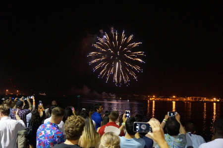 Honolulu - January 1, 2016: New Years Fireworks burst in the air as people watch and record display...