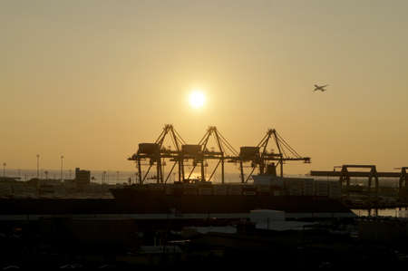 Honolulu - January 12, 2016: Aerial view of Sunset, Shipping Cranes, Matson Shipping Boat, and...