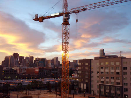 San Francisco - May 14, 2008: Crane at Construction site high up in San Francisco with Caltrain and great skyline in the distance at dusk.のeditorial素材