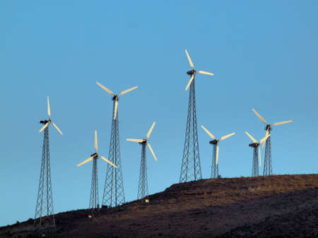 Modern Windmills spin on hillside on California.