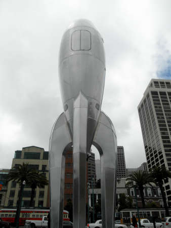 San Francisco - August 11, 2010: 40-foot Raygun Gothic Rocketship sculpture that adorns the San Francisco waterfront at the city's Pier 14 and Bay Bridge in the distance in San Francisco, California.のeditorial素材