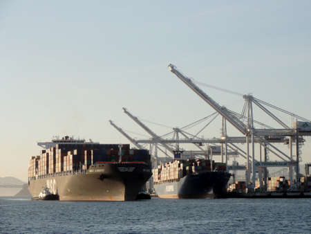 Oakland - November 15, 2011:  MSC Shipping boat pulled by tugboats as another PO Shipping boat is...