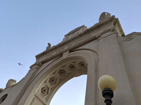 Waikiki -  February 8, 2019:  The Waikiki Natatorium War Memorial at dusk with plane in the sky which is a war memorial in Honolulu, Hawaii, USA, built in the form of an ocean water public swimming pool. The natatorium was built as living memorial dedicatのeditorial素材