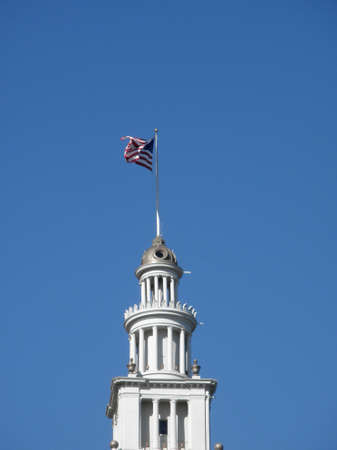San Francisco - November 18, 2009: waterfront landmark - the Ferry Building Clock Tower with flag waving on top.のeditorial素材