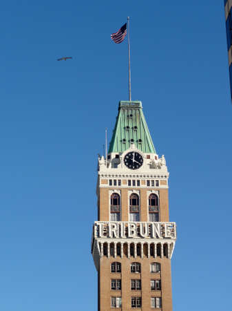 Oakland - February 22, 2011: Tribune Clock Tower with bird flying in Downtown Oakland, California.