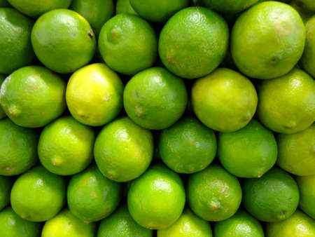 Limes stacked on top of each other on display in market.の写真素材