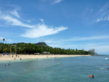Waikiki, Hawaii - July 13, 2014:  People play in calm ocean water at Queens Beach in Waikiki with Diamondhead in the distance.のeditorial素材
