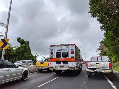 Honolulu - July 8, 2021:  Cars and Trucks Traffic separate to make way for Ambulance Van on Pali Road.のeditorial素材