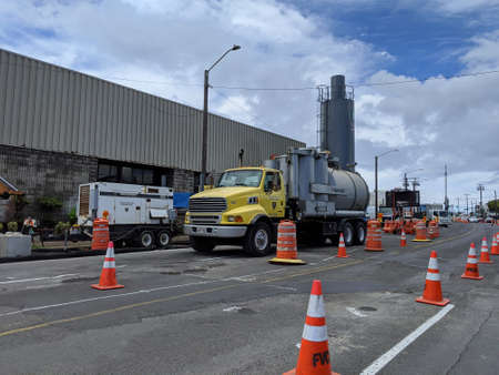 Honolulu - July 13, 2021: Construction machines do sewage road repair in the middle of intersection in the Honolulu, Hawaii area.のeditorial素材