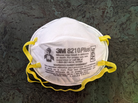 Honolulu - August 1, 2020: Two White N95 Face Masks with yellow ear straps made by 3M on floor.のeditorial素材