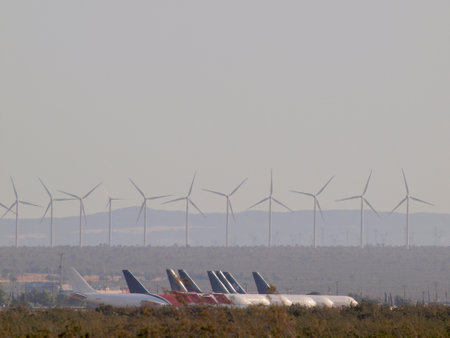 California - August 1, 2011:  Row of retired aircrafts parked at storage facility with windmills in the distance in the Mojave Air & Space Port.のeditorial素材