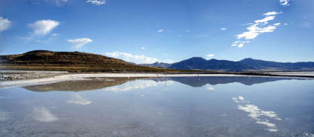 Jetty extend into the water off the shore of Great Salt Lake, Utah, United States on a nice day with clouds reflecting on the water.  Panoramic.の写真素材