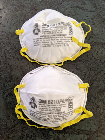 Honolulu - August 1, 2020: Two White N95 Face Masks with yellow ear straps made by 3M on floor.のeditorial素材