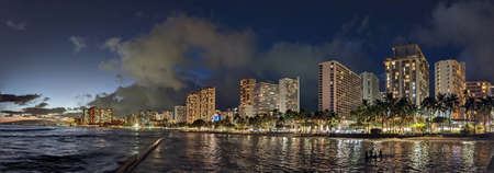 Panoramic of Ocean waters of Waikiki Beach at Night with Hotels aloing the coast seen from the Kapahulu Groin.の写真素材