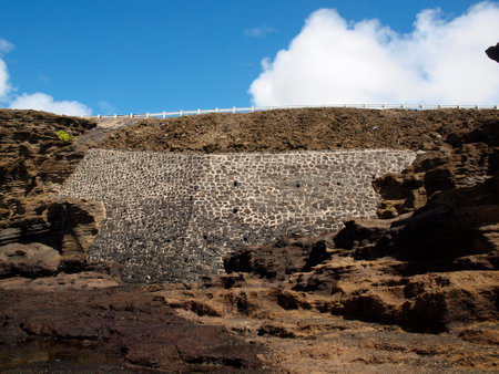 Old Wall Supports road on Kalaniana'ole Highway along lava rock shore on Oahu, Hawaii.の写真素材