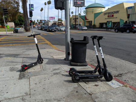 LA, California, United States - October 16, 2019: Bird Scooters parked on sidewalk in front of off broadway shoe warehouseのeditorial素材