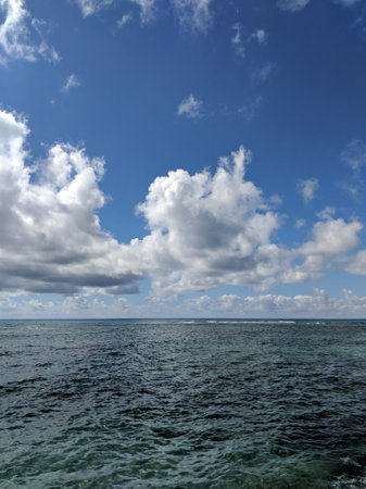 Shallow ocean waters of Waikiki looking into the pacific ocean with clouds in the sky.の写真素材