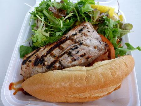 A sandwich with fish, lettuce and tomato on it.の写真素材