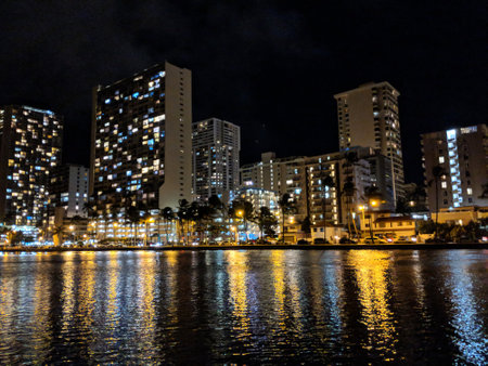Waikiki City skyline at night with building lights reflecting on Ala Wai Canal water on Oahu, Hawaii.の写真素材