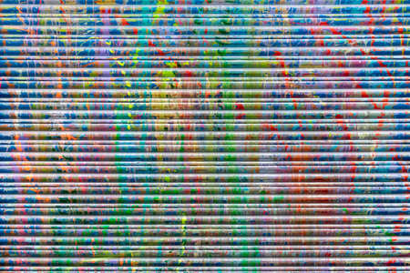 Bright Abstract Paint Colors Dripping Down a Textured Wallの写真素材