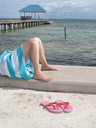Relaxing on the concrete sea wall with Pink Sandalsの写真素材